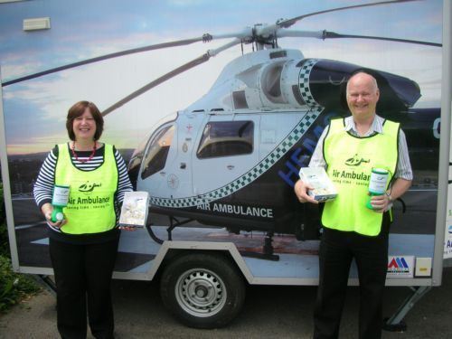 Volenteres with collecting tins  -  in front of helicoptor