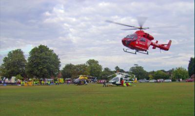 Red helicopter above village green