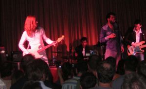 man in white playing guitar