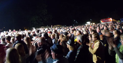 Crowd scene at night lit up by search light